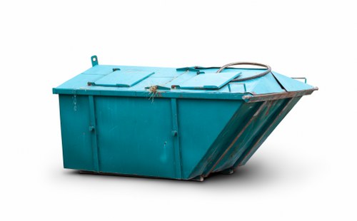 A large industrial skip bin painted in a shade of turquoise sits outdoors on a paved surface, likely a driveway or service area, with its lid closed. The skip has a sturdy metal construction with visible vertical reinforcement ridges along its sides and a slightly sloped front panel for easy loading. A black rubber tire tube is draped over the top edge, and a small chain is attached near the lid for securing it. The environment appears clean and well-maintained, with no other objects or debris visible around the skip. The background is plain or blank, emphasizing the skip's prominent placement, suggesting a setting suitable for commercial waste collection or rubbish removal services. This image is relevant for a waste management company like Commercial Waste Poplar offering rubbish removal solutions in the Poplar area, which is within London postcode E14, and demonstrates the typical equipment used in waste collection activities.